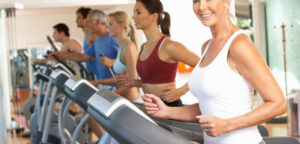 Senior Woman On Running Machine In Gym