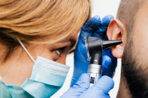 Dottoressa ispeziona orecchio del paziente