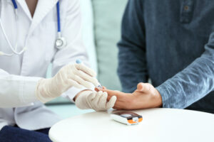 Ddottore misura glicemia a paziente diabetico