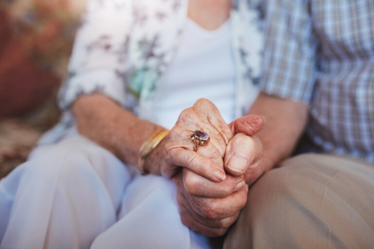 Coppia anziana si tiene per mano: esmepio di amore che vince su covid