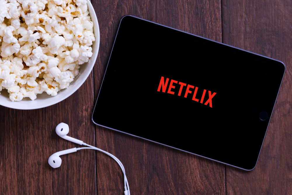 Tablet con scritta Netflix e popcorn: esempio dis erie Netflix con protagonisti senior