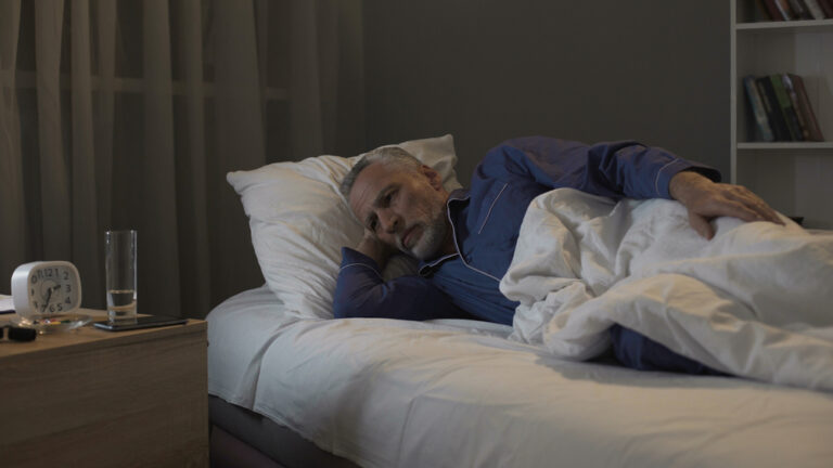 Uomo a letto che soffre di insonnia