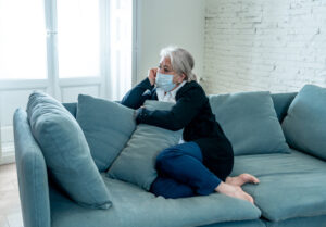 Donna depressa su divano: esempio di effetti isolamento su over 60