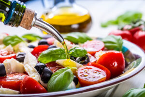 Esempio di dieta mediterranea green: piatto con verdure, olio d'oliva, olive, formaggio